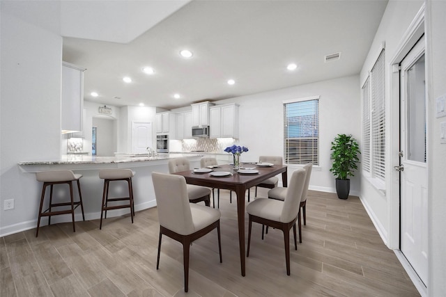 dining area featuring sink and light hardwood / wood-style flooring