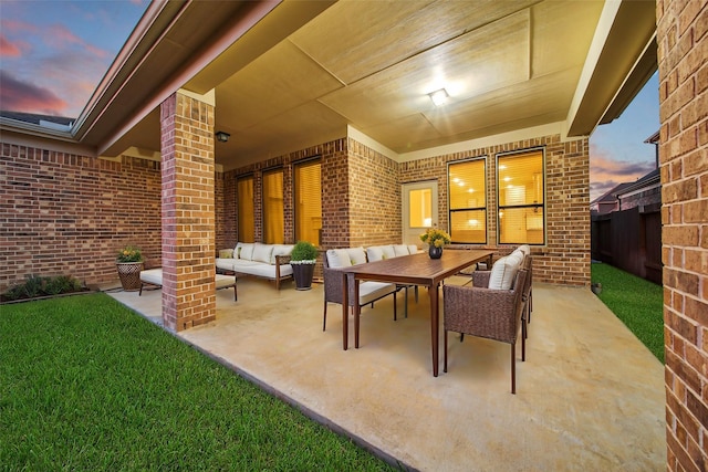 patio terrace at dusk featuring an outdoor hangout area and a lawn