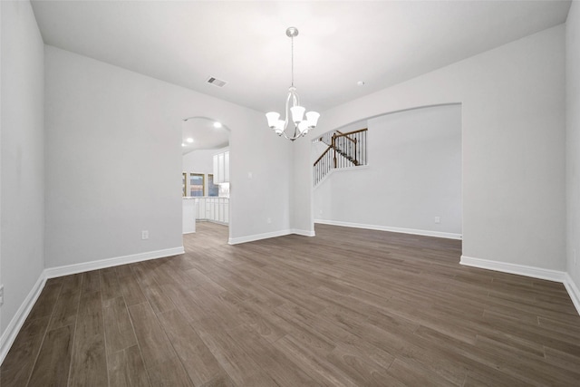 unfurnished dining area featuring dark wood-type flooring and a chandelier