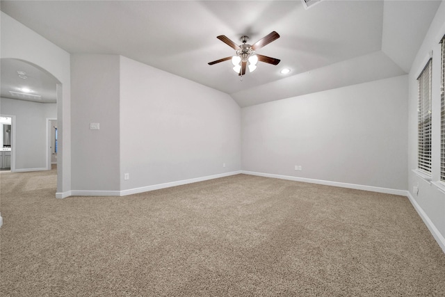 carpeted empty room featuring vaulted ceiling and ceiling fan