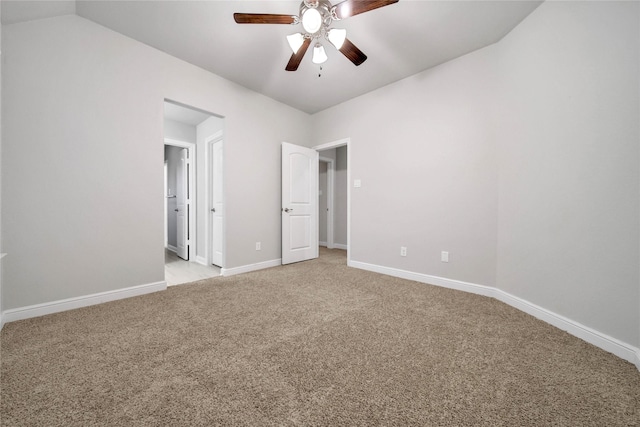 unfurnished bedroom featuring vaulted ceiling, light colored carpet, and ceiling fan