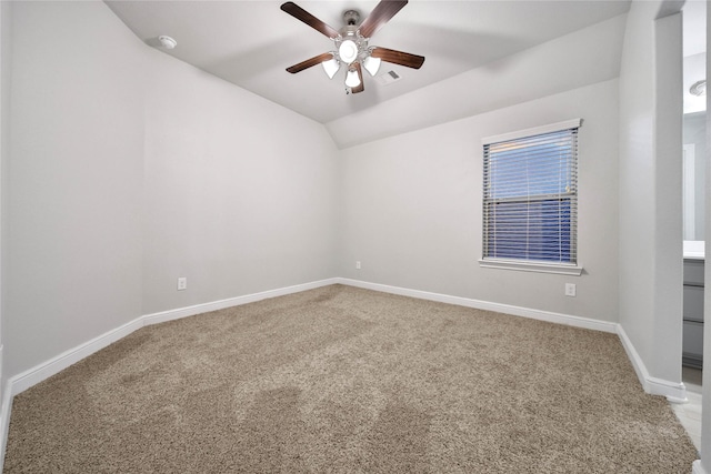 spare room featuring ceiling fan, light colored carpet, and lofted ceiling