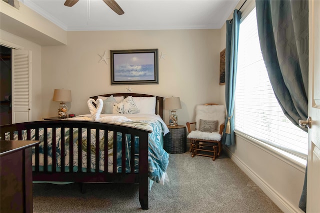 bedroom featuring ceiling fan, ornamental molding, carpet flooring, and multiple windows