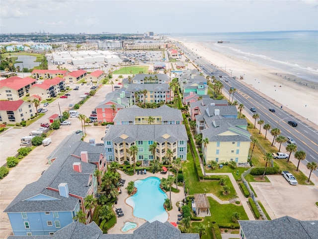 birds eye view of property with a water view and a beach view