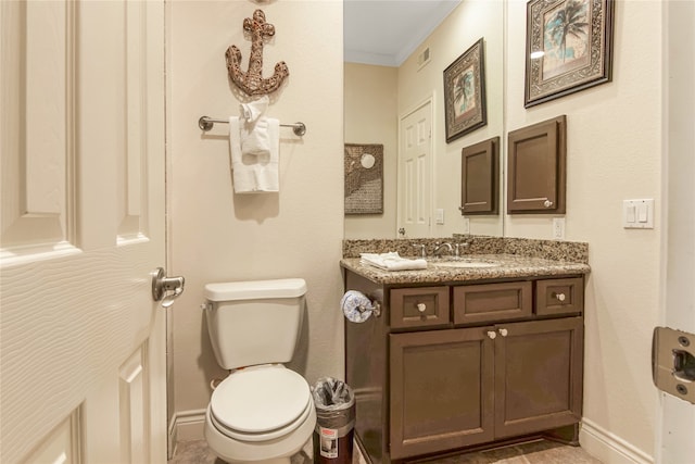 bathroom with crown molding, vanity, and toilet