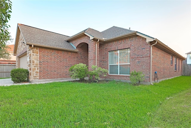 ranch-style home with a garage and a front lawn