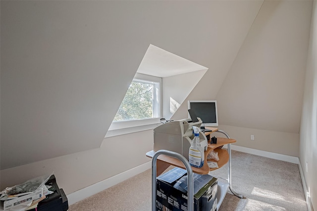 carpeted office space featuring lofted ceiling and baseboards