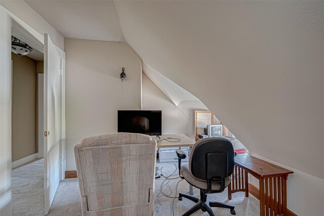 office space featuring lofted ceiling and light colored carpet