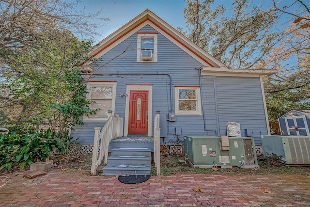 view of front of home featuring central air condition unit, an outdoor structure, and a shed