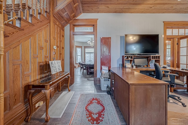 office featuring dark wood-style flooring, an inviting chandelier, vaulted ceiling, wooden walls, and wooden ceiling