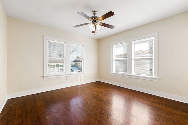 spare room with dark wood-type flooring and ceiling fan