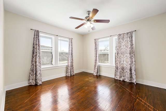 empty room with ceiling fan, plenty of natural light, and dark hardwood / wood-style flooring