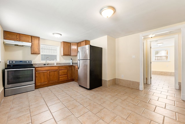 kitchen featuring stainless steel appliances, sink, and light tile patterned floors