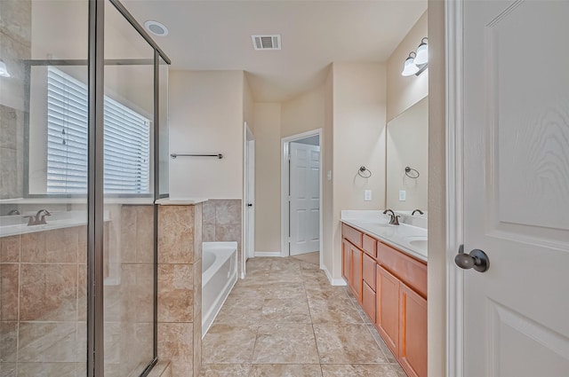 bathroom with vanity and shower with separate bathtub