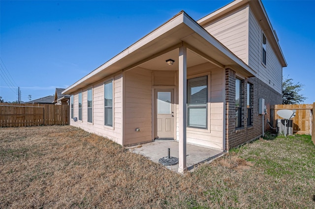 rear view of property featuring a patio area and a lawn