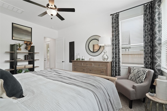 bedroom with multiple windows, visible vents, and a ceiling fan