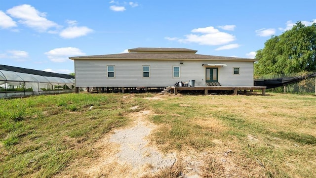 rear view of property featuring an outbuilding and a yard