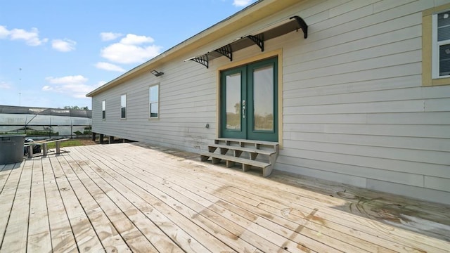 wooden deck featuring a lanai and french doors