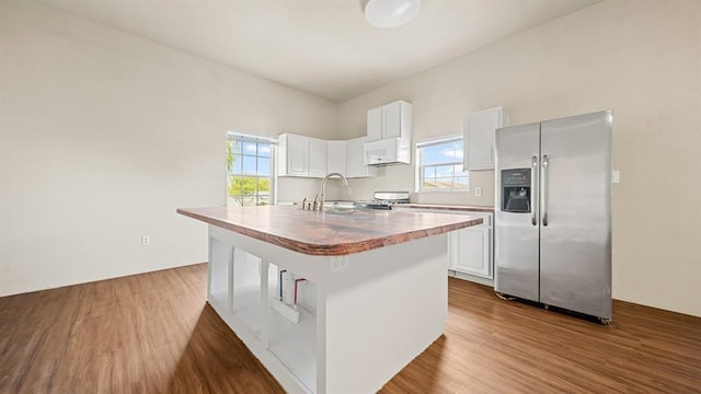 kitchen featuring sink, white cabinetry, stainless steel fridge with ice dispenser, hardwood / wood-style flooring, and a kitchen island with sink