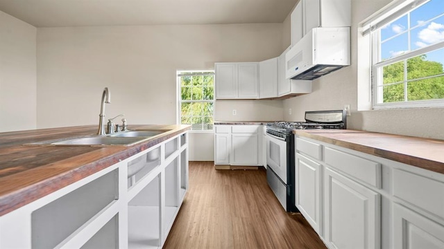 kitchen with white cabinets, butcher block counters, sink, and stainless steel gas range oven