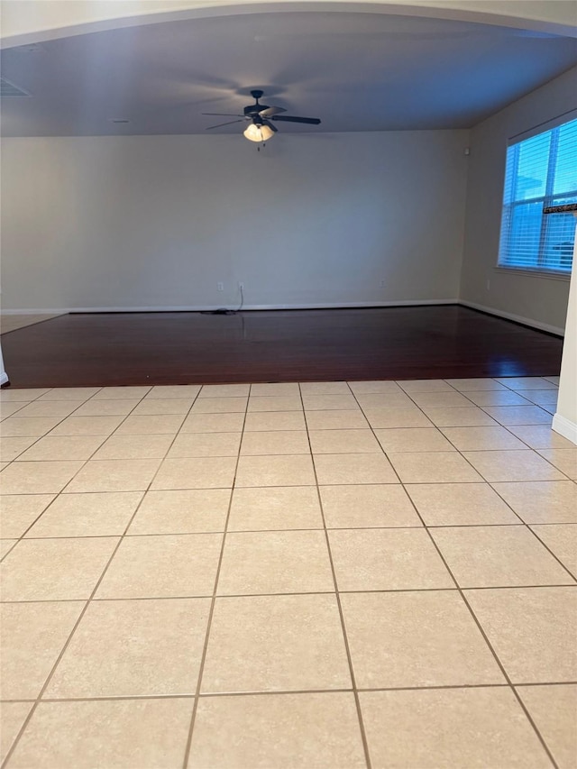 tiled spare room featuring ceiling fan