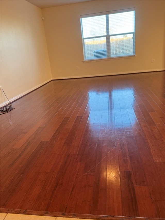 empty room featuring dark wood-type flooring and plenty of natural light