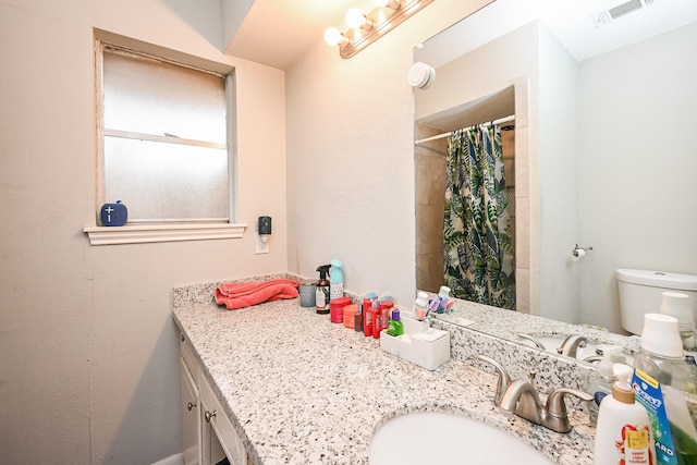 bathroom featuring vanity, toilet, and a shower with shower curtain