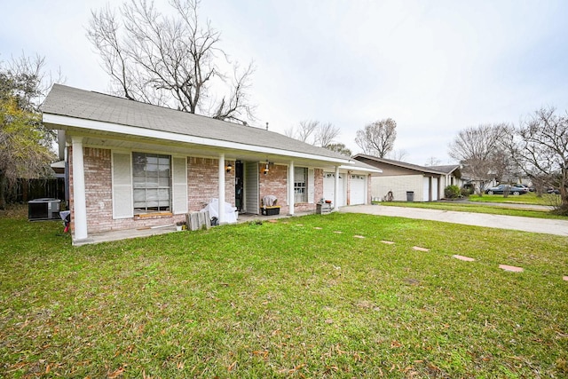 ranch-style house with a garage, a front yard, covered porch, and central air condition unit