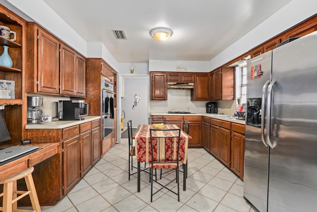 kitchen with appliances with stainless steel finishes, a breakfast bar, and light tile patterned floors