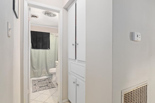 bathroom with tile patterned flooring, ornamental molding, a shower with shower curtain, and toilet