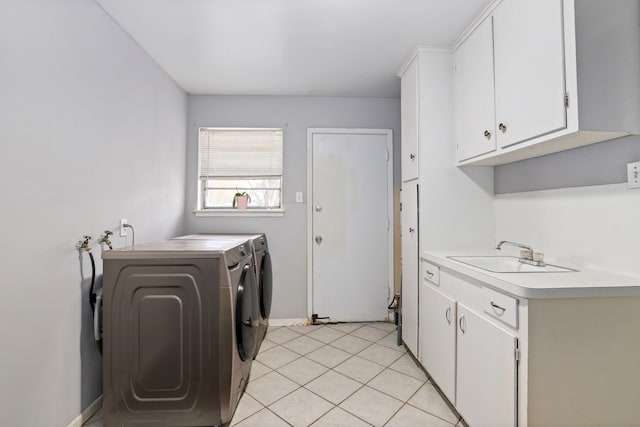 laundry room with light tile patterned flooring, cabinets, sink, and washer and dryer