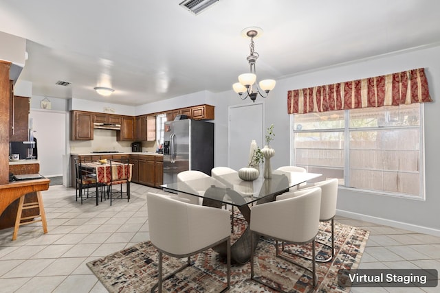 dining room with a chandelier and light tile patterned floors