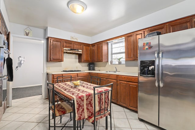 kitchen with appliances with stainless steel finishes, sink, and light tile patterned floors