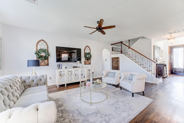 living room featuring dark wood-type flooring and ceiling fan