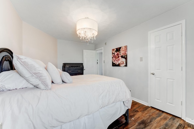 bedroom featuring dark wood-type flooring and an inviting chandelier