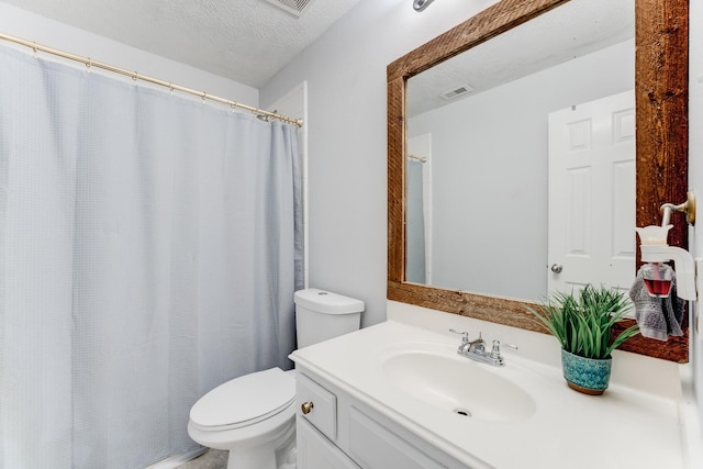 bathroom featuring vanity, toilet, and a textured ceiling