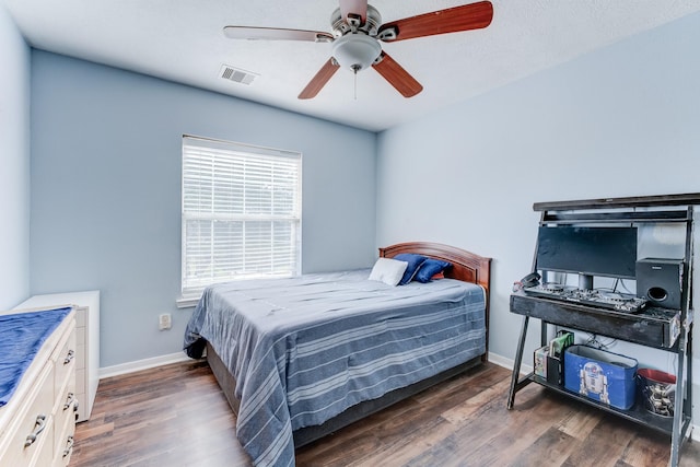 bedroom with dark hardwood / wood-style floors and ceiling fan