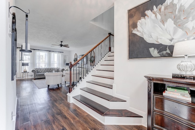 stairs featuring hardwood / wood-style floors, a textured ceiling, and ceiling fan