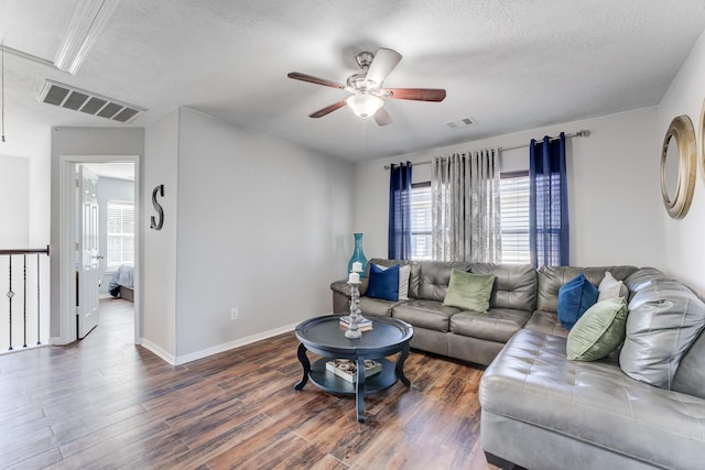 living room with ceiling fan, dark hardwood / wood-style floors, and a textured ceiling