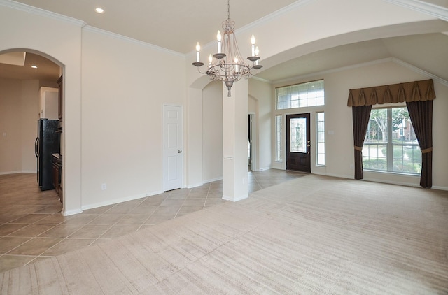 interior space featuring ornamental molding, a high ceiling, and a notable chandelier