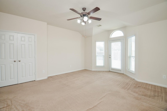 carpeted empty room featuring lofted ceiling and ceiling fan