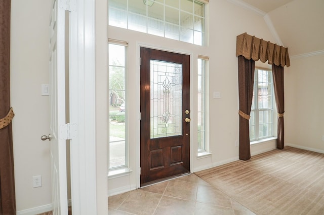 tiled entrance foyer featuring crown molding and a healthy amount of sunlight