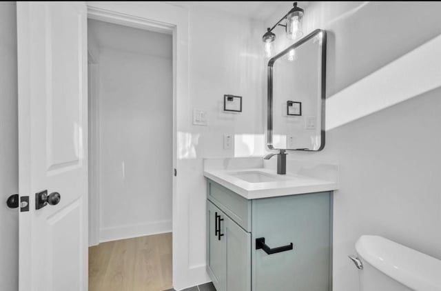 bathroom featuring vanity, toilet, and wood-type flooring