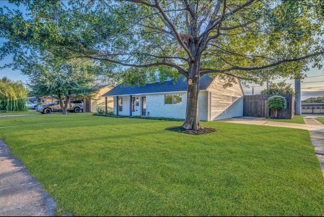 ranch-style home featuring a garage and a front lawn