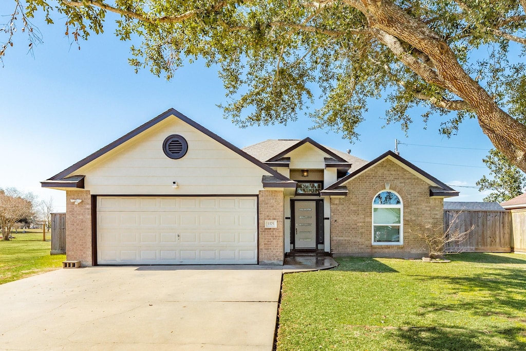 ranch-style house featuring a garage and a front lawn