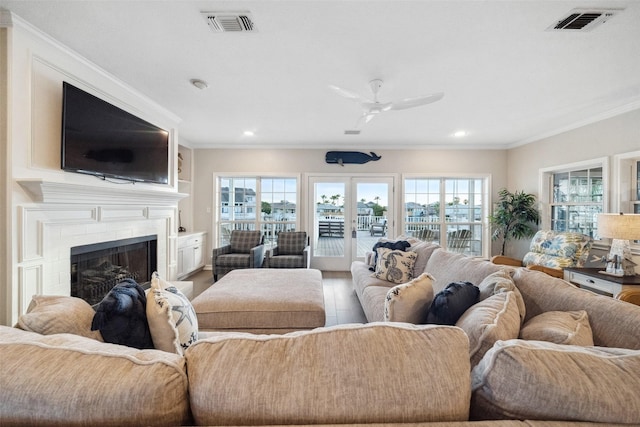 living room with crown molding, a healthy amount of sunlight, french doors, and hardwood / wood-style flooring