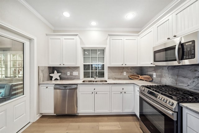 kitchen featuring sink, decorative backsplash, white cabinets, and appliances with stainless steel finishes