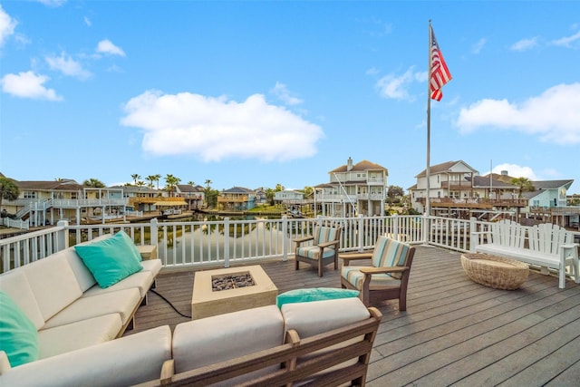 wooden deck with an outdoor living space with a fire pit and a water view