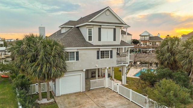 coastal home featuring a balcony and a garage