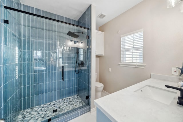 bathroom with vanity, a shower with shower door, tile patterned floors, and toilet